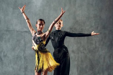 Balo dansı sambası. Sarı ve siyah kostümlü genç çift dans ediyor..