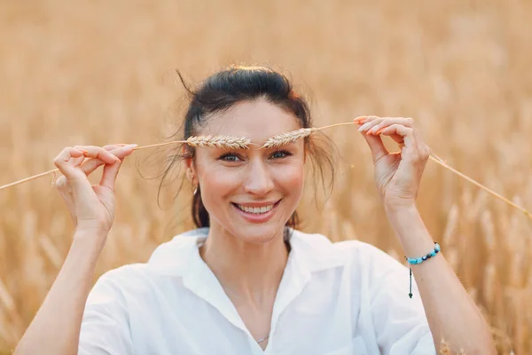 Ritratto di una bella donna bruna sorridente con spighe di grano sulle sopracciglia — Foto Stock