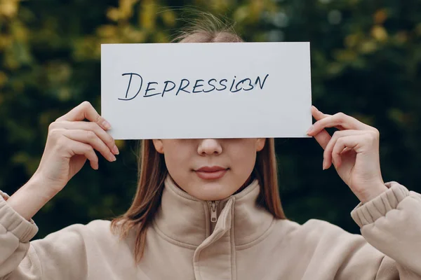 Wanita memegang lembaran putih kertas berlabel Depresi kata di tangan. — Stok Foto