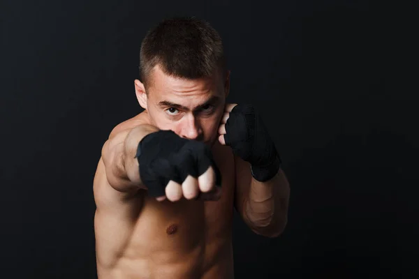 Deportista hombre boxeador postura puñetazo jab en negro fondo —  Fotos de Stock