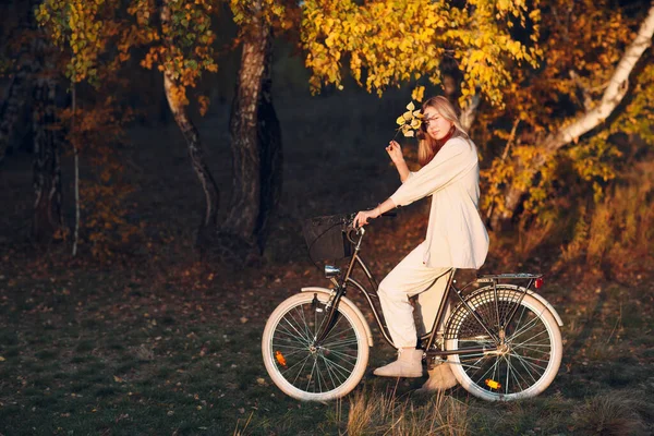 Feliz jovem ativo andando de bicicleta no parque de outono — Fotografia de Stock