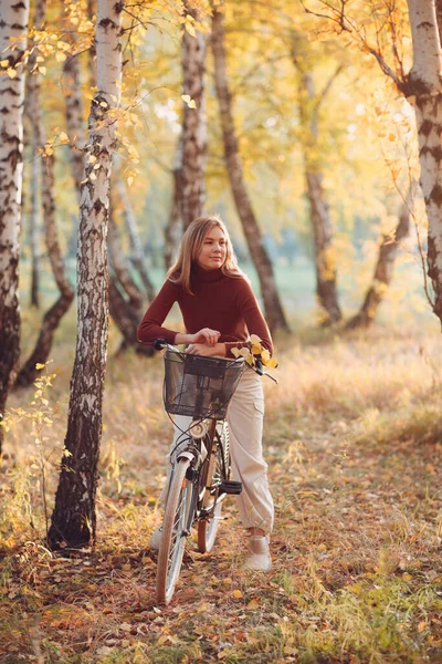 Happy active młoda kobieta jazda vintage rower w jesiennym parku o zachodzie słońca — Zdjęcie stockowe