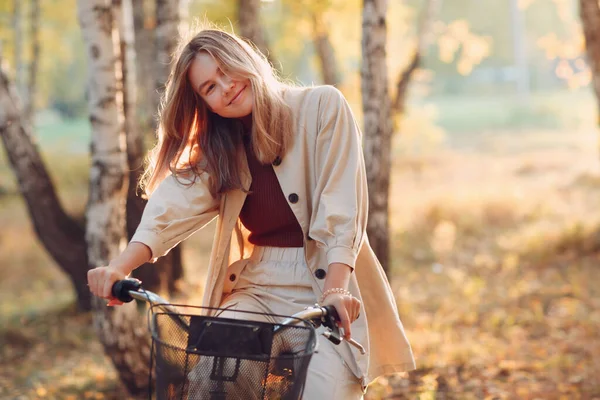 Szczęśliwy uśmiechnięta młoda kobieta jazda vintage rower w jesiennym parku o zachodzie słońca — Zdjęcie stockowe