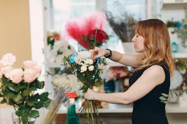 Kwiaciarnia kobieta dokonać bukiet w kwiat butik — Zdjęcie stockowe