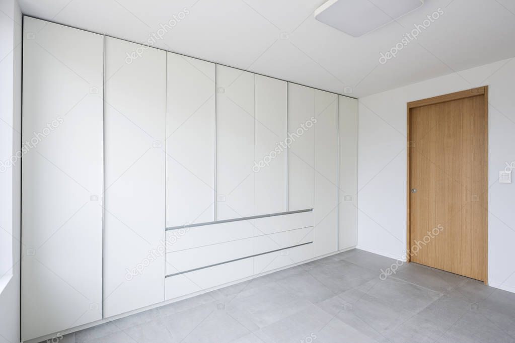 the white room with the white closet(wardrobe) at the daylight.