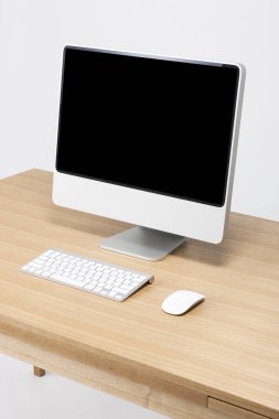Bilgisayar beyaz arkaplanda, tahta masada..