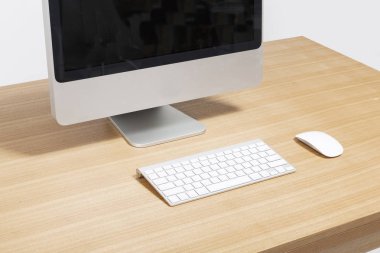 Bilgisayar beyaz arkaplanda, tahta masada..