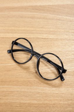 Ahşap masada siyah gözlük.