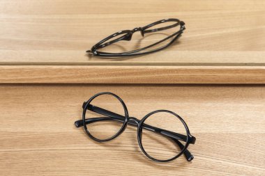 Ahşap masada siyah gözlük.