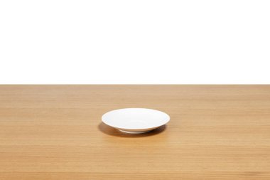 Beyaz arkaplanda izole edilmiş ahşap masada boş bir tabak..