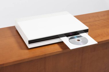 Tahta sehpanın üzerinde CD çalar var..