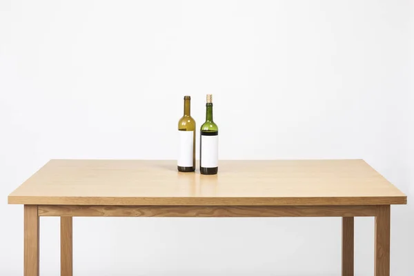 两个酒瓶 木桌上的杯子 — 图库照片