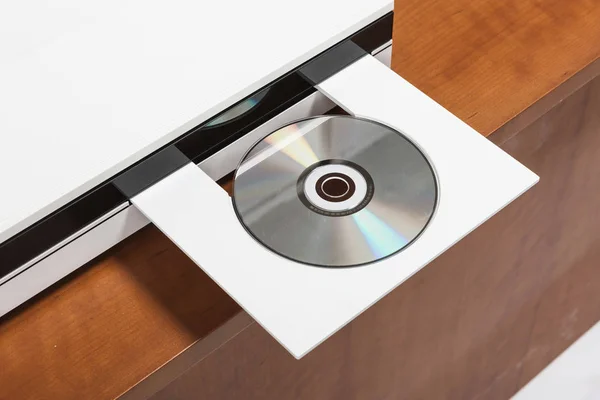 white cd player with cd on the wood table.