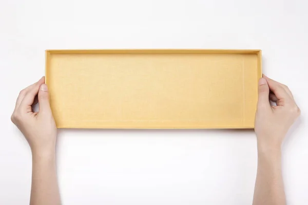 女人的手拿着一个黄色的纸盒隔离在白色背景上 — 图库照片