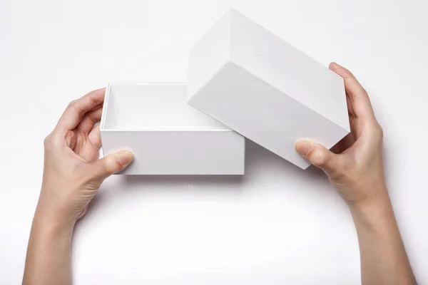 Frauenhand Hält Eine Weiße Schachtel Auf Dem Weißen Tisch — Stockfoto