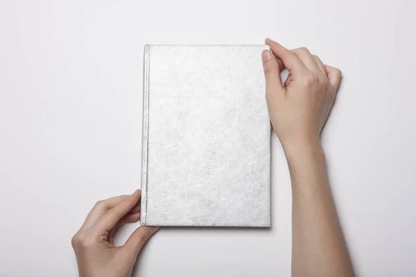 Mão Mulher Segura Uma Capa Livro Vazia Mesa Branca — Fotografia de Stock