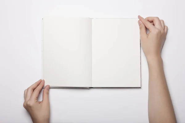 Vrouw Hand Houden Een Leeg Boek Verspreid Witte Tafel — Stockfoto