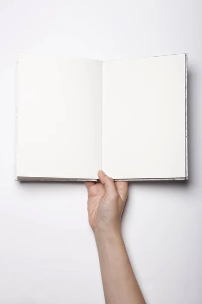 Vrouw Hand Houden Een Leeg Boek Verspreid Witte Tafel — Stockfoto
