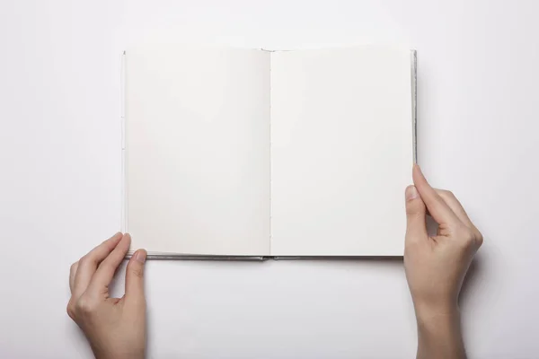 Vrouw Hand Houden Een Leeg Boek Verspreid Witte Tafel — Stockfoto