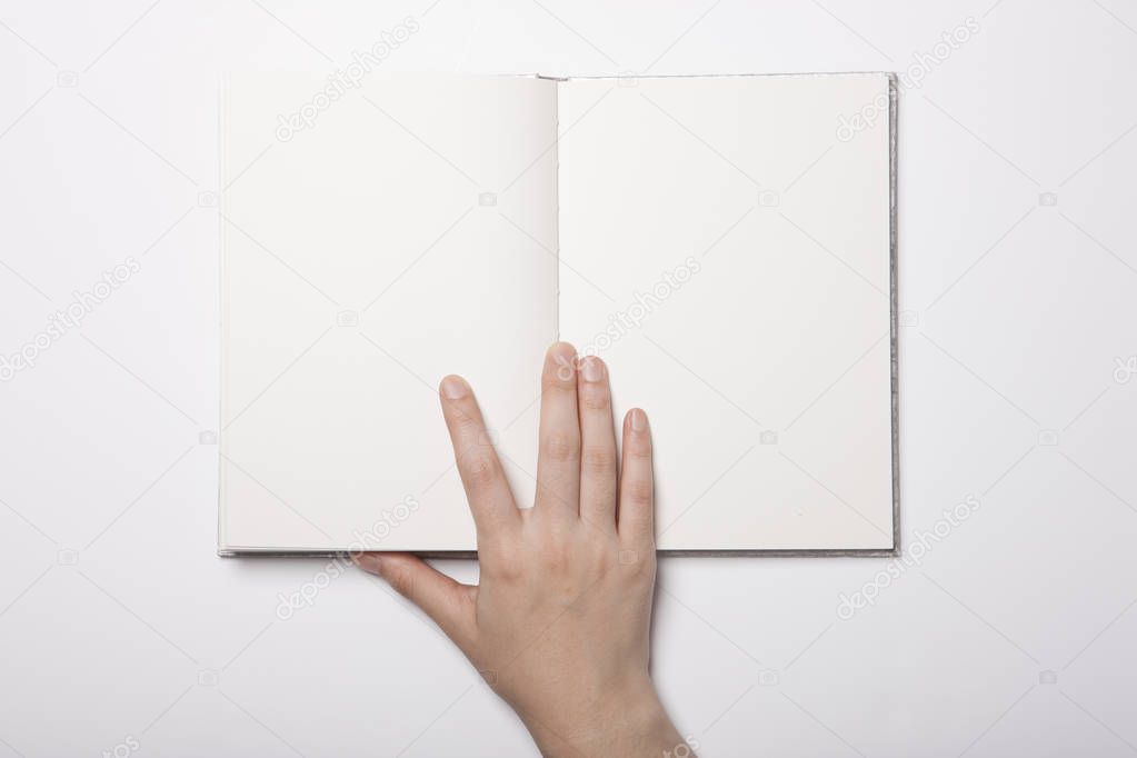 Woman hand hold a book on the white table