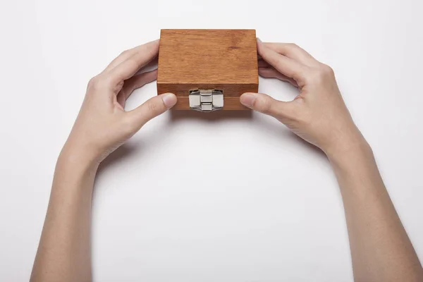 Γυναικείο Χέρι Κρατά Ένα Ξύλινο Κουτί Στο Λευκό Τραπέζι — Φωτογραφία Αρχείου