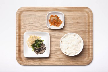 Kore kahvaltısı, kimchi, pirinç, sebze ve ahşap tepside..