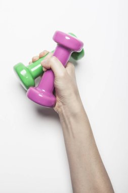 Kadın el ele tutuşup beyaz arka planda bir Dumbbell tutuyor.