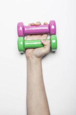 Kadın el ele tutuşup beyaz arka planda bir Dumbbell tutuyor.