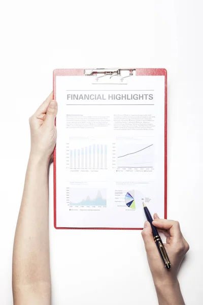 woman hand hold a clip board with financial paper on the white table.