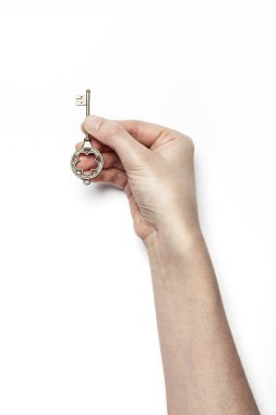 Kadın eli beyaz masada anahtarı tutuyor..