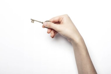 Kadın eli beyaz masada anahtarı tutuyor..