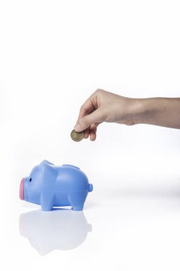 Yansıması ile beyaz arka plan üzerinde bir kumbara üzerinde sikke ile El