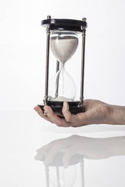 Kadın (kadın) bir vintage kum zamanlayıcı izole beyaz el ele.