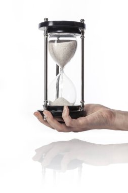 Kadın (kadın) bir vintage kum zamanlayıcı izole beyaz el ele.