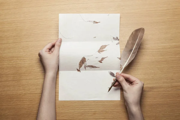 woman hand hold a pen with letter on the wood table.