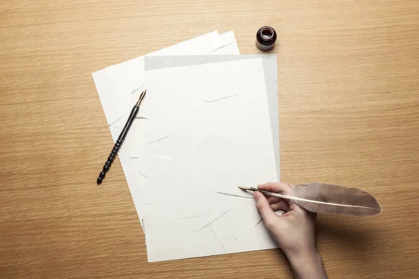 woman hand hold a pen with letter on the wood table.