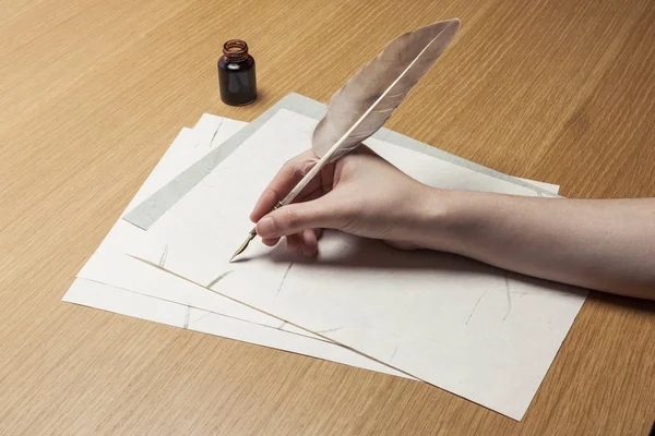 woman hand hold a pen with letter on the wood table.