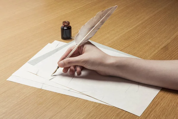 woman hand hold a pen with letter on the wood table.