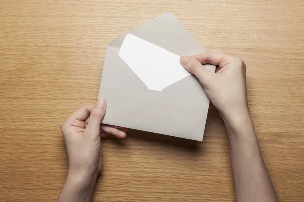 woman hand hold a envelope, letter on the wood table,