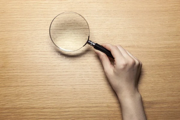 Mano Mujer Sostenga Una Lupa Mesa Madera — Foto de Stock