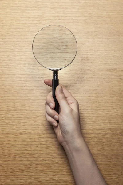 Vrouw Hand Houden Een Vergrootglas Houten Tafel — Stockfoto