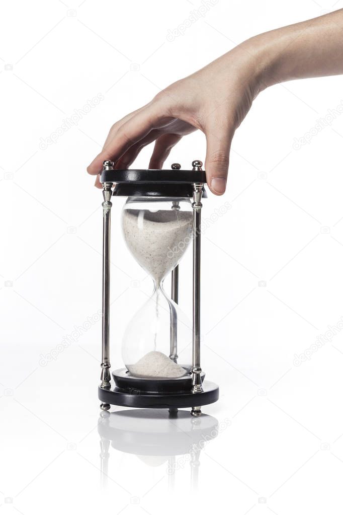 woman(female) hand hold a vintage sand timer isolated white.