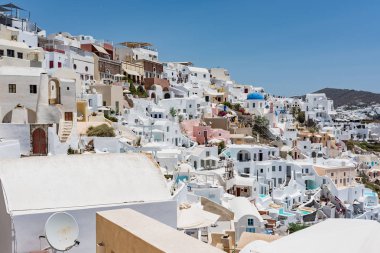 Küçük küçük beyaz evleri, oteller, kafeler ve havuzları ve Santorini, Yunanistan, Oia köyünde küçük kiliseler.