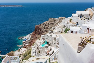 Küçük küçük beyaz evler, oteller, kafeler ve havuzları ve Santorini, Yunanistan, Oia köyünde küçük kiliseler. Limana görüntülemek.