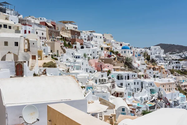 Küçük küçük beyaz evleri, oteller, kafeler ve havuzları ve Santorini, Yunanistan, Oia köyünde küçük kiliseler.