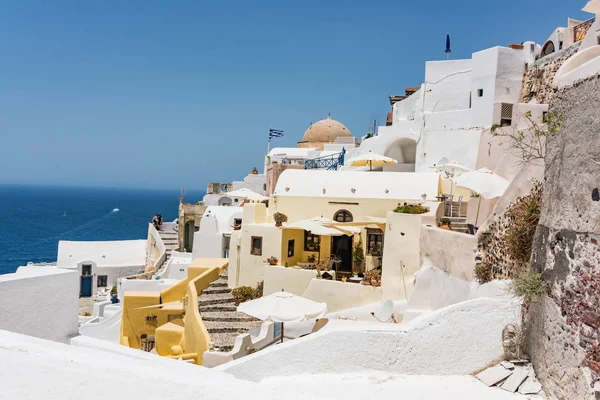 Tiny little white houses, hotels with cafes and pools and small churches in the Oia village at Thira island, Greece.