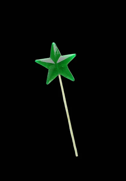Házi nyalóka. Zöld csillag alakú nyalókát elszigetelt fekete backgruond. — Stock Fotó