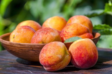 bir tabloda sokakta bir kasede olgun şeftali