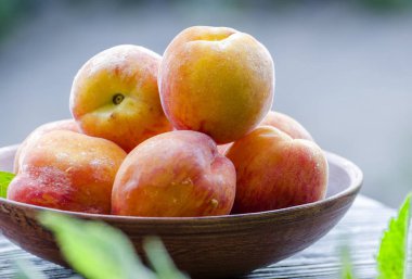 bir tabloda sokakta bir kasede olgun şeftali