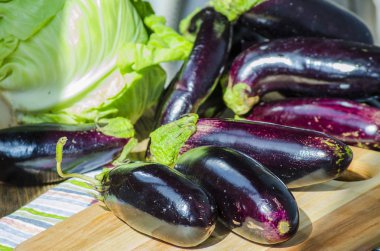 bir kara tahta üzerinde taze mor patlıcan demet